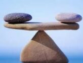 three rocks balanced on tip of another depicting importance of balance