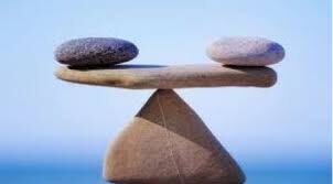 three rocks balanced on tip of another depicting importance of balance