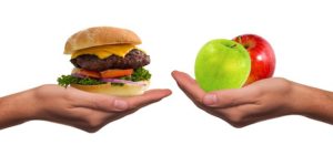 hands showing a burger vs two apples alternative diet